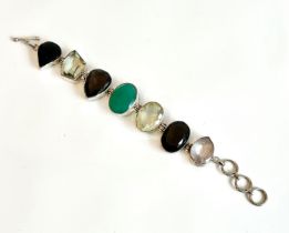 A silver and multigem bracelet - the seven faceted stones including a green agate, smoky quartz,