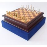 A cased chess set and board - late 20th century, the silver-coloured and gold-coloured cast metal
