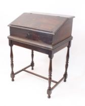 A late-18th century oak clerk's desk - the hinged lid with book-rest, enclosing a simply fitted