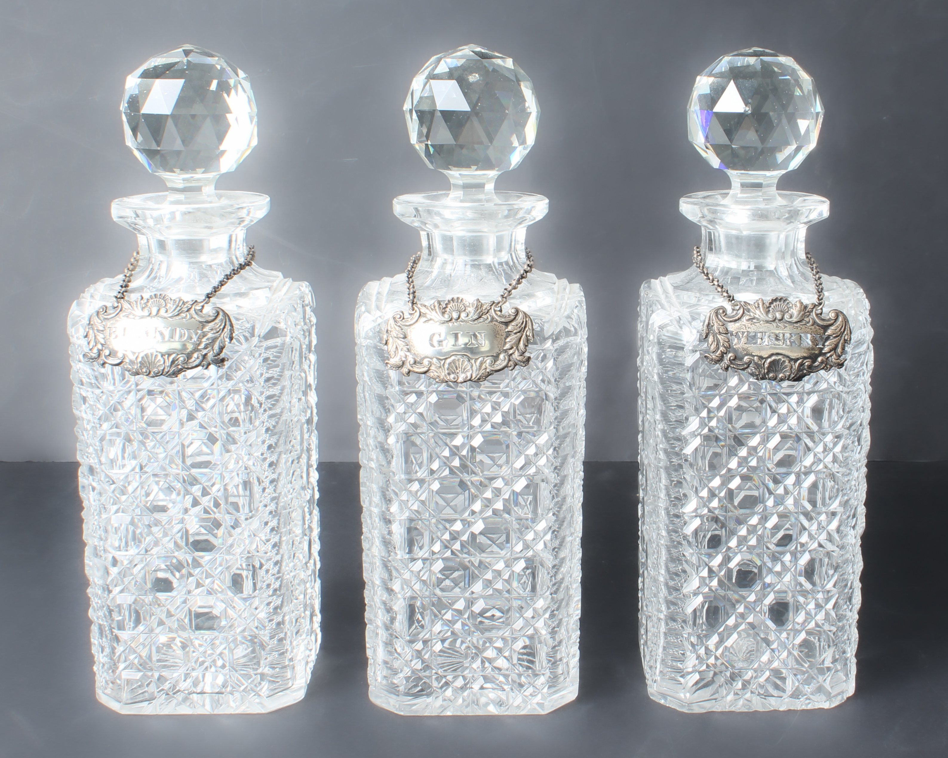 Seven cut glass decanters - a trio of early 20th century square hobnail cut tantalus decanters - Image 2 of 5