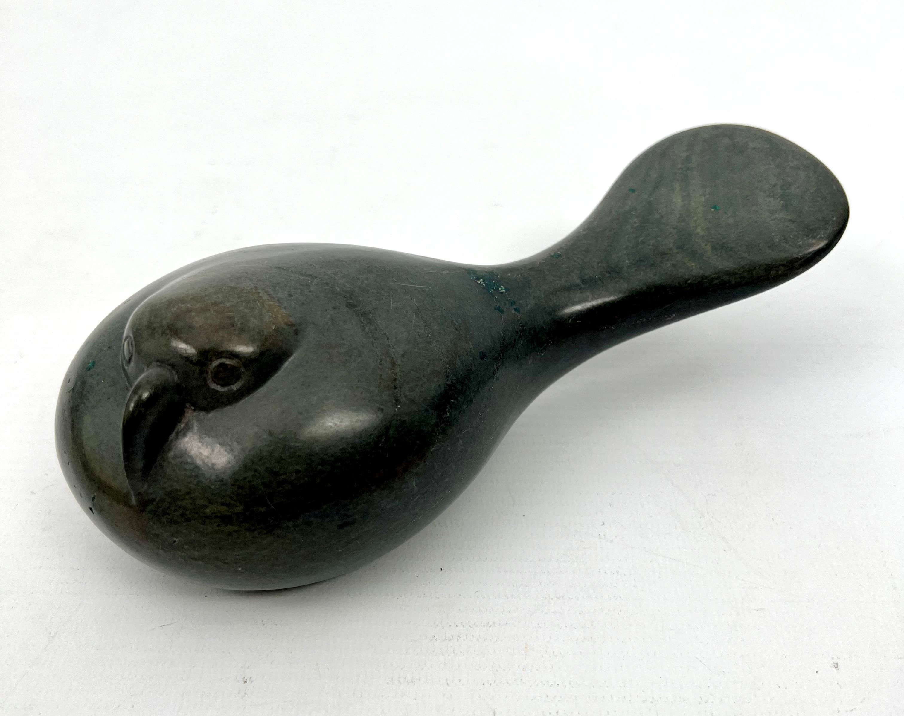 An Inuit carved stone sculpture of a resting bird - in green stone, its head huddled down on its - Image 2 of 5