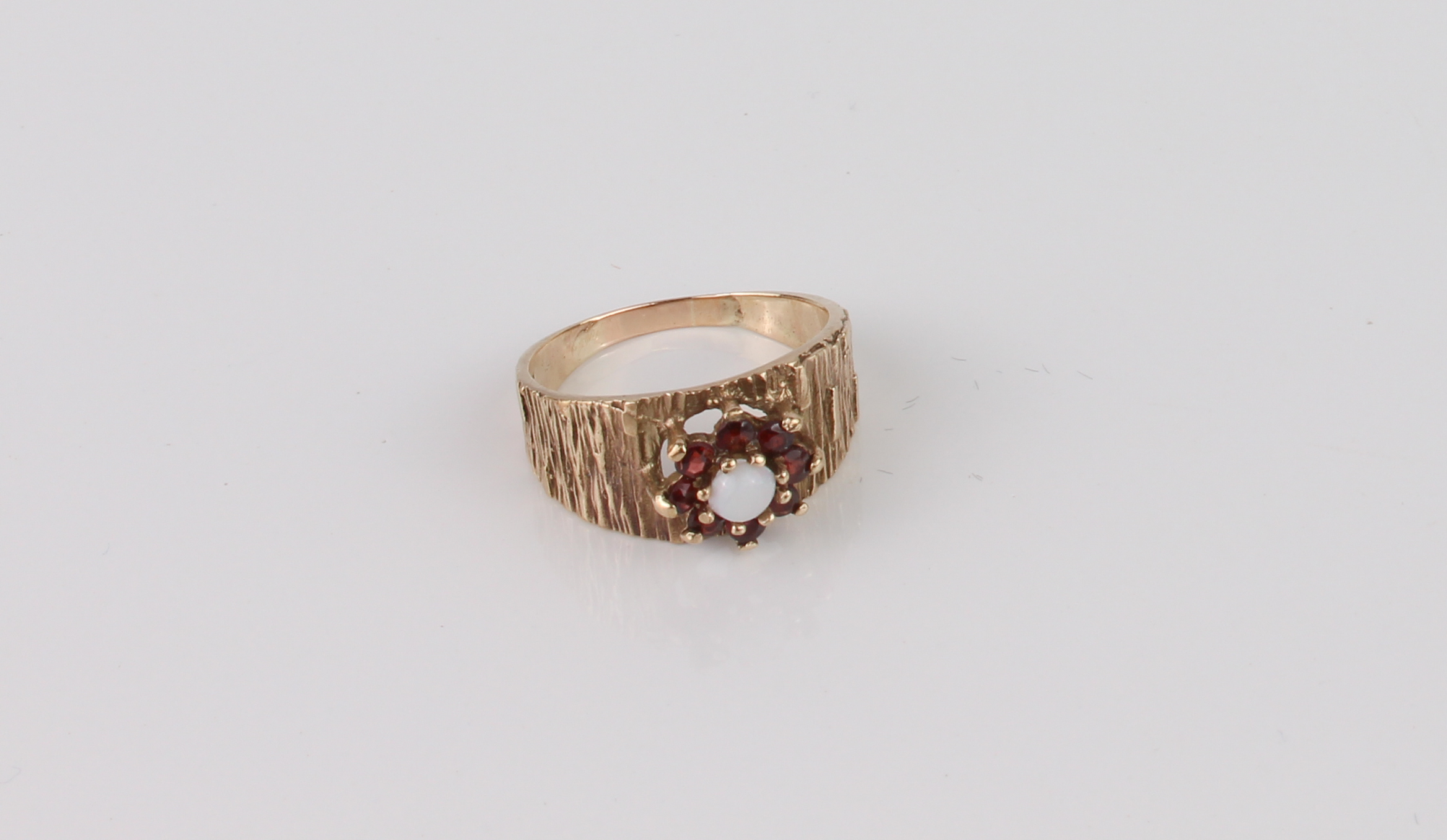 A vintage 9ct gold, white opal and garnet cluster ring - stamped '9CT', with bark effect