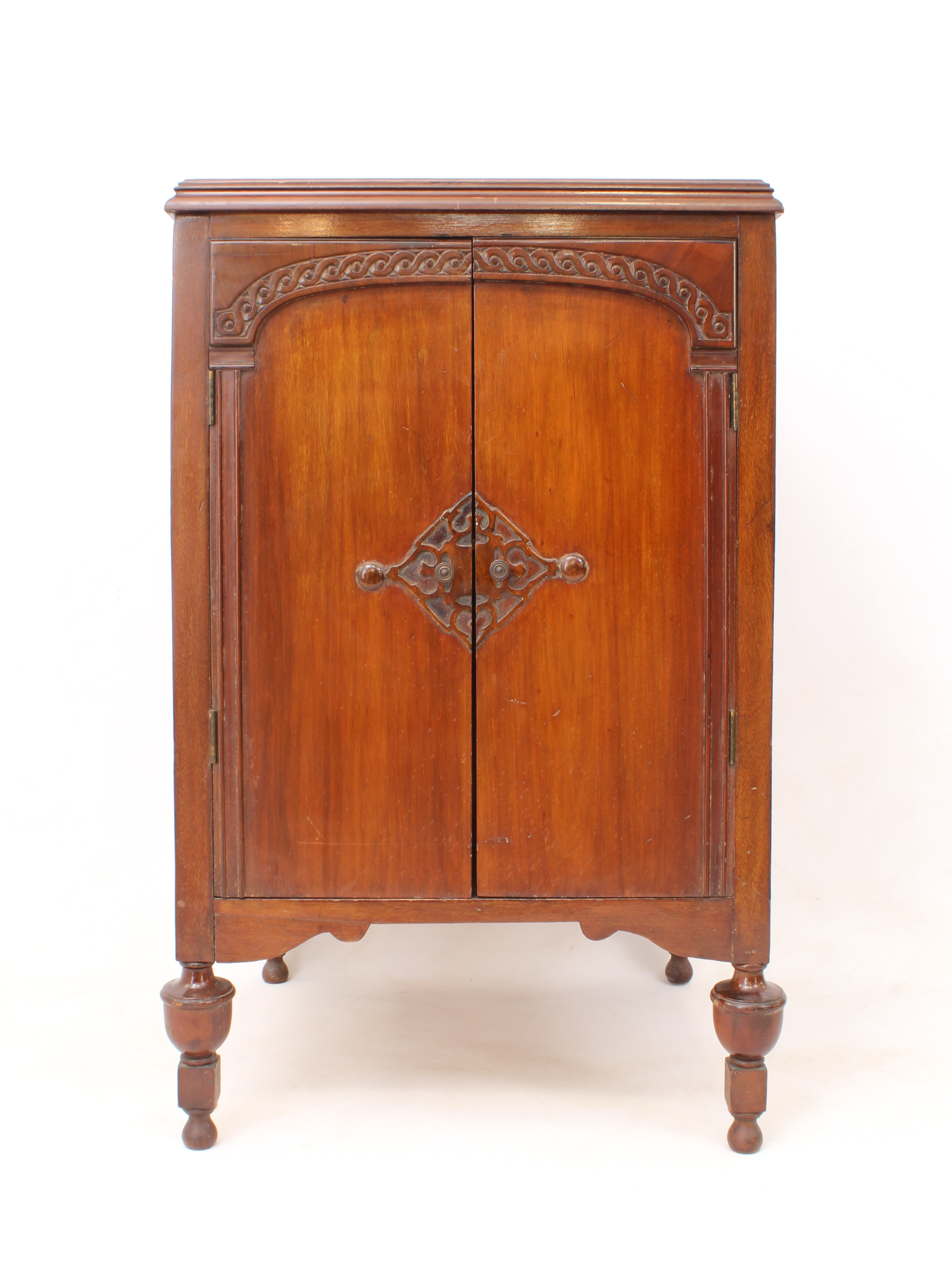A 1920s-30s mahogany two-door record cabinet - the moulded top over a pair of doors carved with