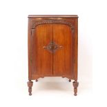 A 1920s-30s mahogany two-door record cabinet - the moulded top over a pair of doors carved with