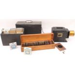 A cased magic lantern and a good quantity of slides to include: a mahogany and gilt-brass hand-