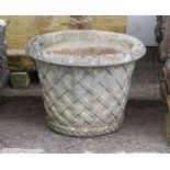 A  composite stone garden planter - well weathered, of tapering cylindrical form, interlaced lattice