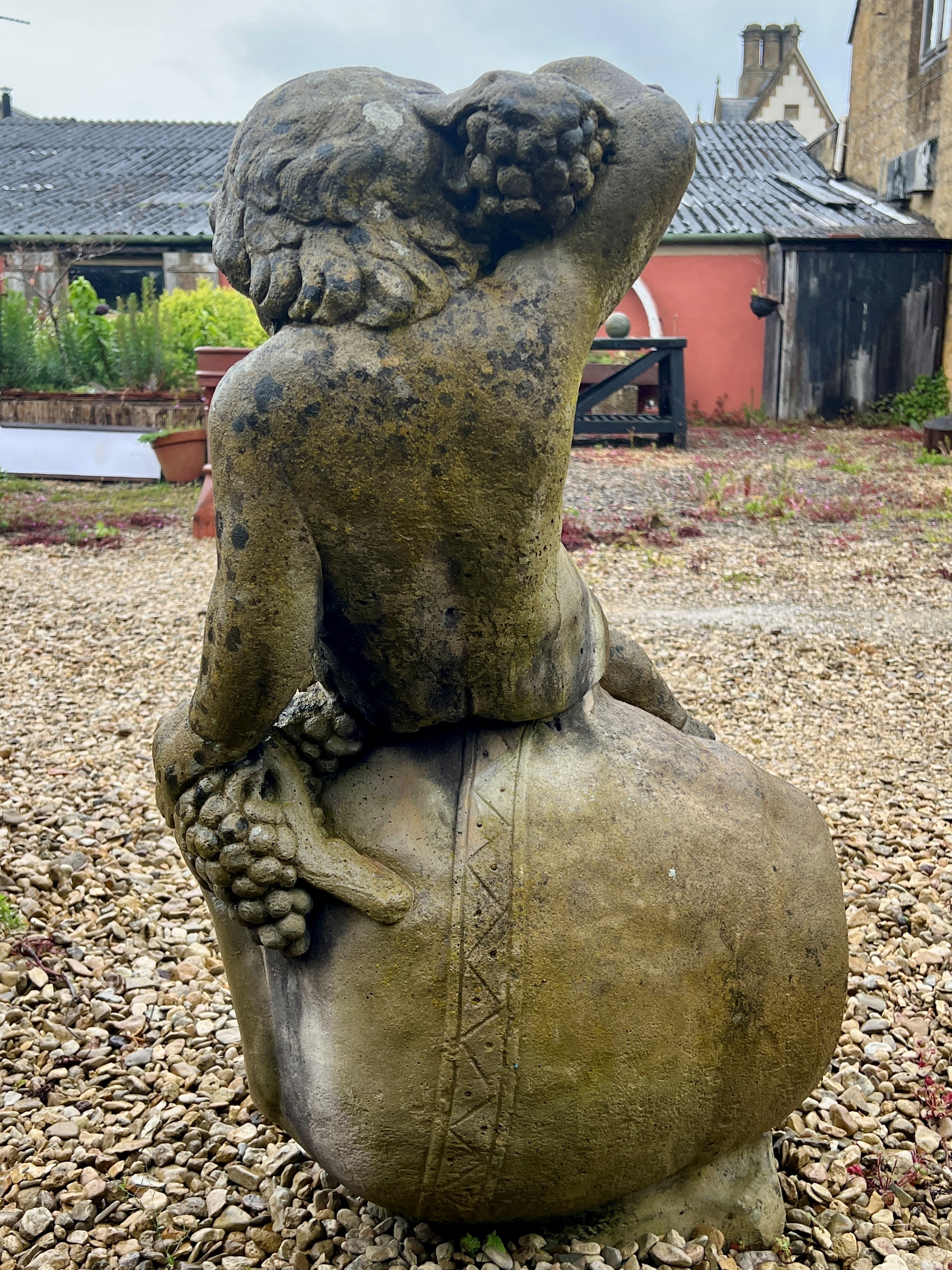 A composite stone statue of the young Bacchus sitting upon an upturned wine jar - 53 x 43cm x 90cm - Image 3 of 4