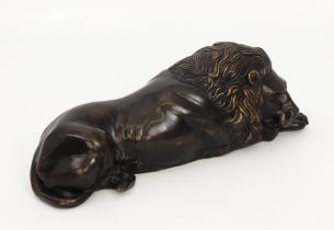 A modern bronze model of a recumbent lion (26 x 9 cm).