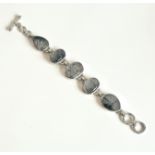 A silver and rutilated quartz bracelet - with five oval and teardrop cabochon stones in rub-over