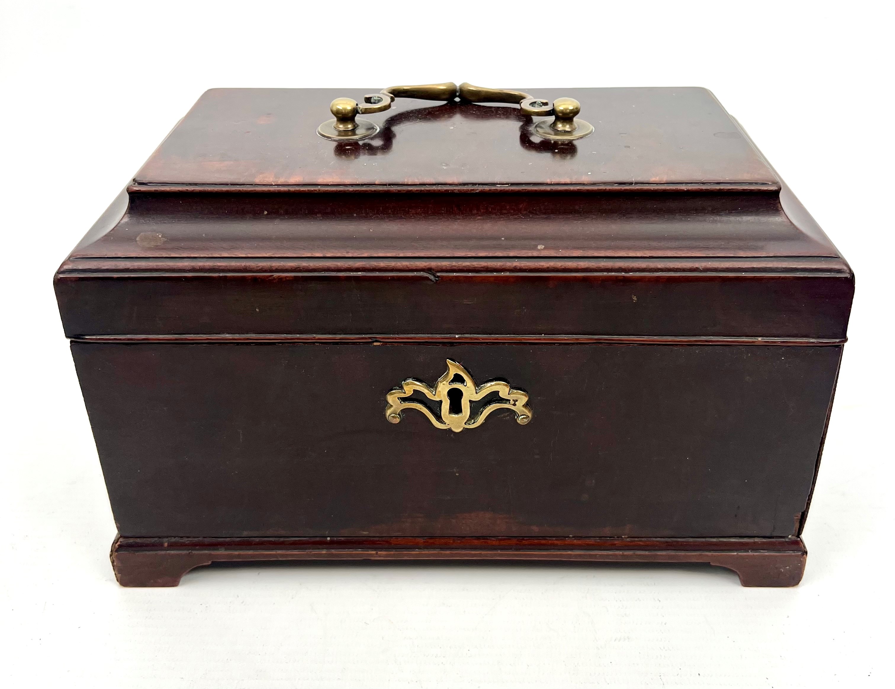 A George III mahogany sarcophagus tea caddy - with original brass handle and pierced escutcheon,