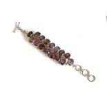 A sterling silver and amethyst bracelet - stamped 925, set with two rows of alternate oval and