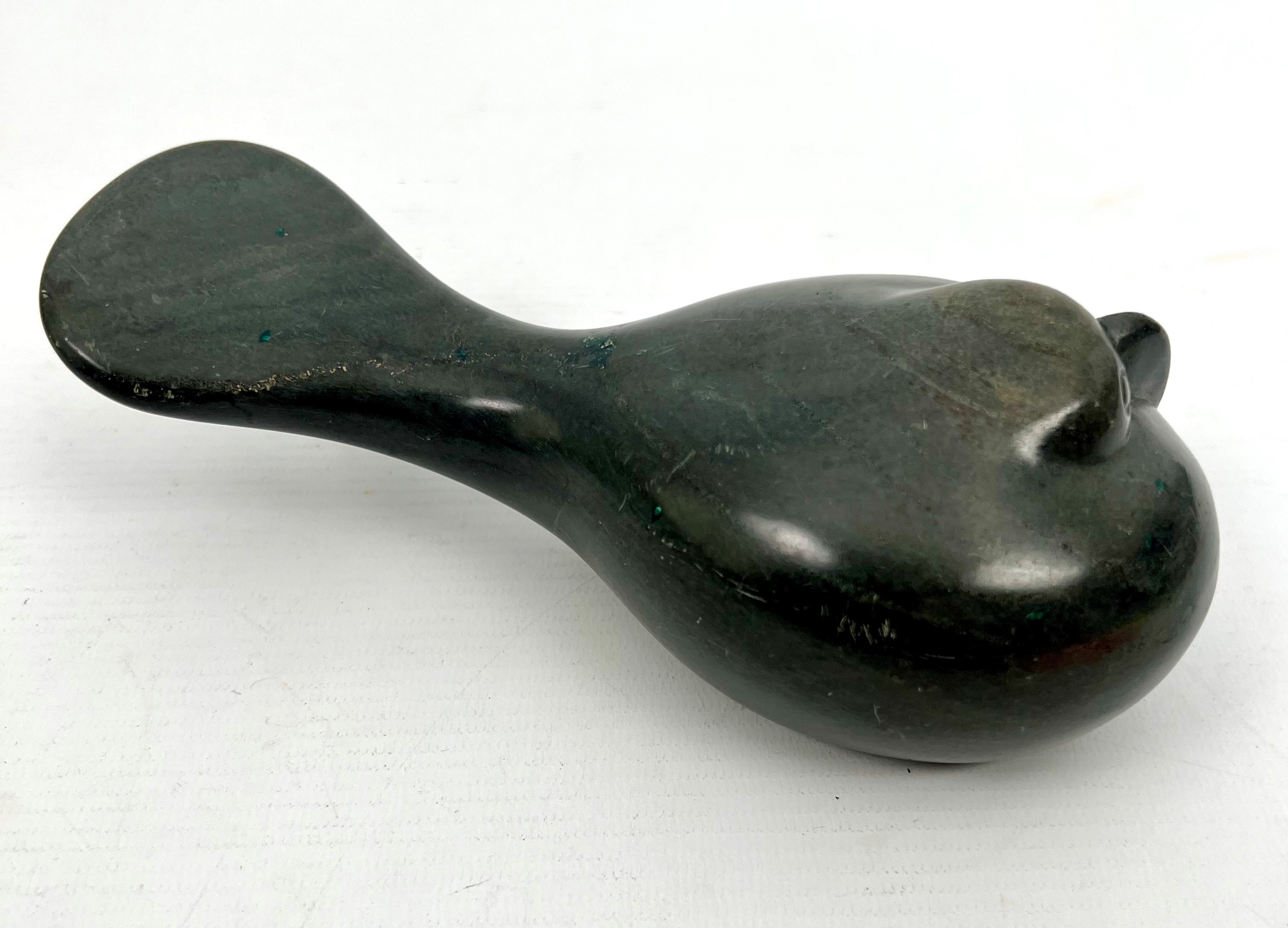 An Inuit carved stone sculpture of a resting bird - in green stone, its head huddled down on its - Image 3 of 5