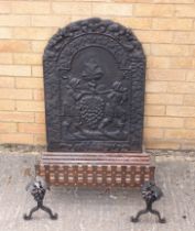 A cast iron fireback with wrought iron grate and firedogs - the arched fireback with cast decoration