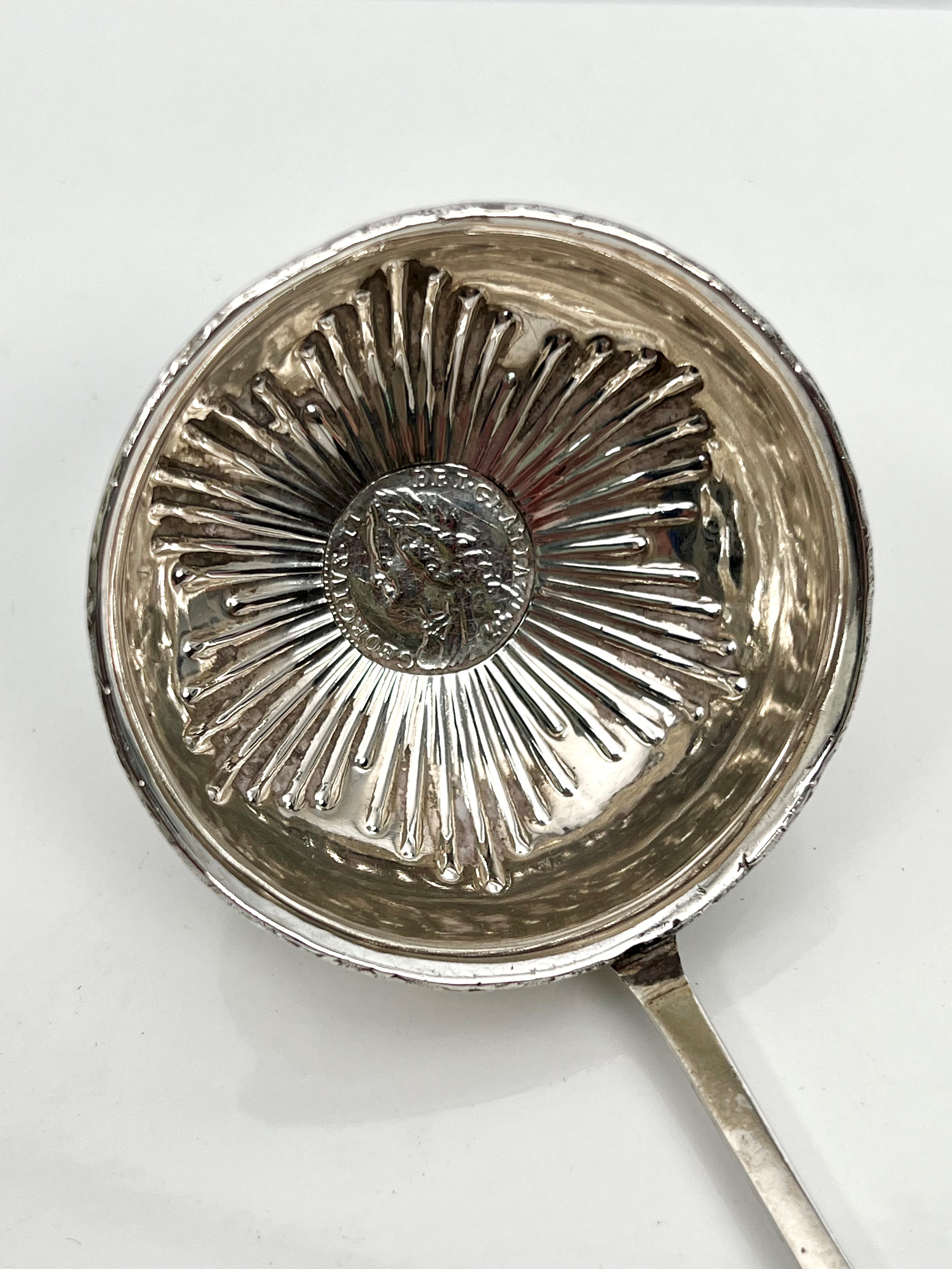 A Georgian white metal toddy ladle - unmarked, the circular bowl with repoussé flowerhead decoration - Bild 2 aus 3