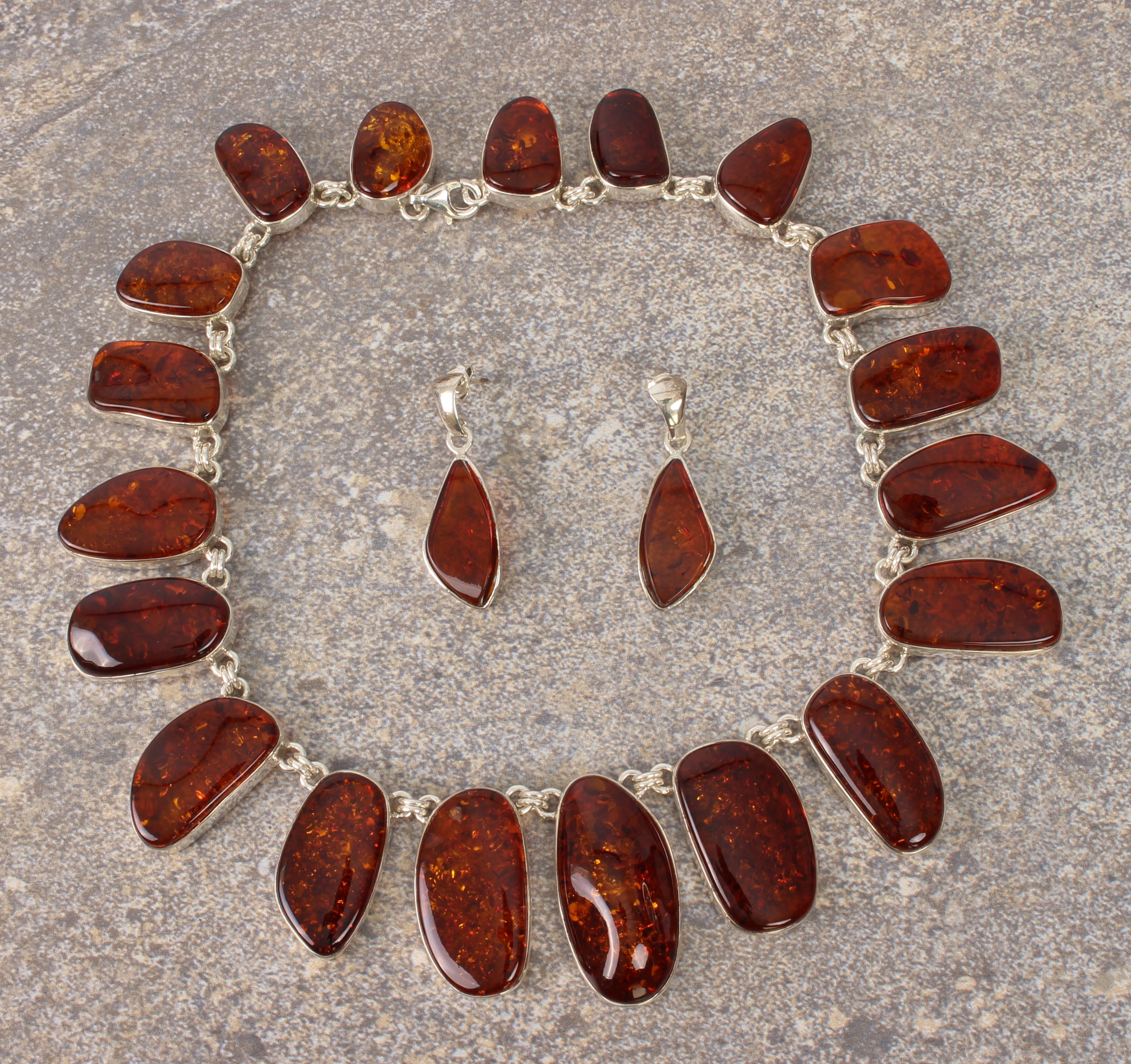 A suite of sterling silver and Baltic amber jewellery - all with naturalistically shaped polished