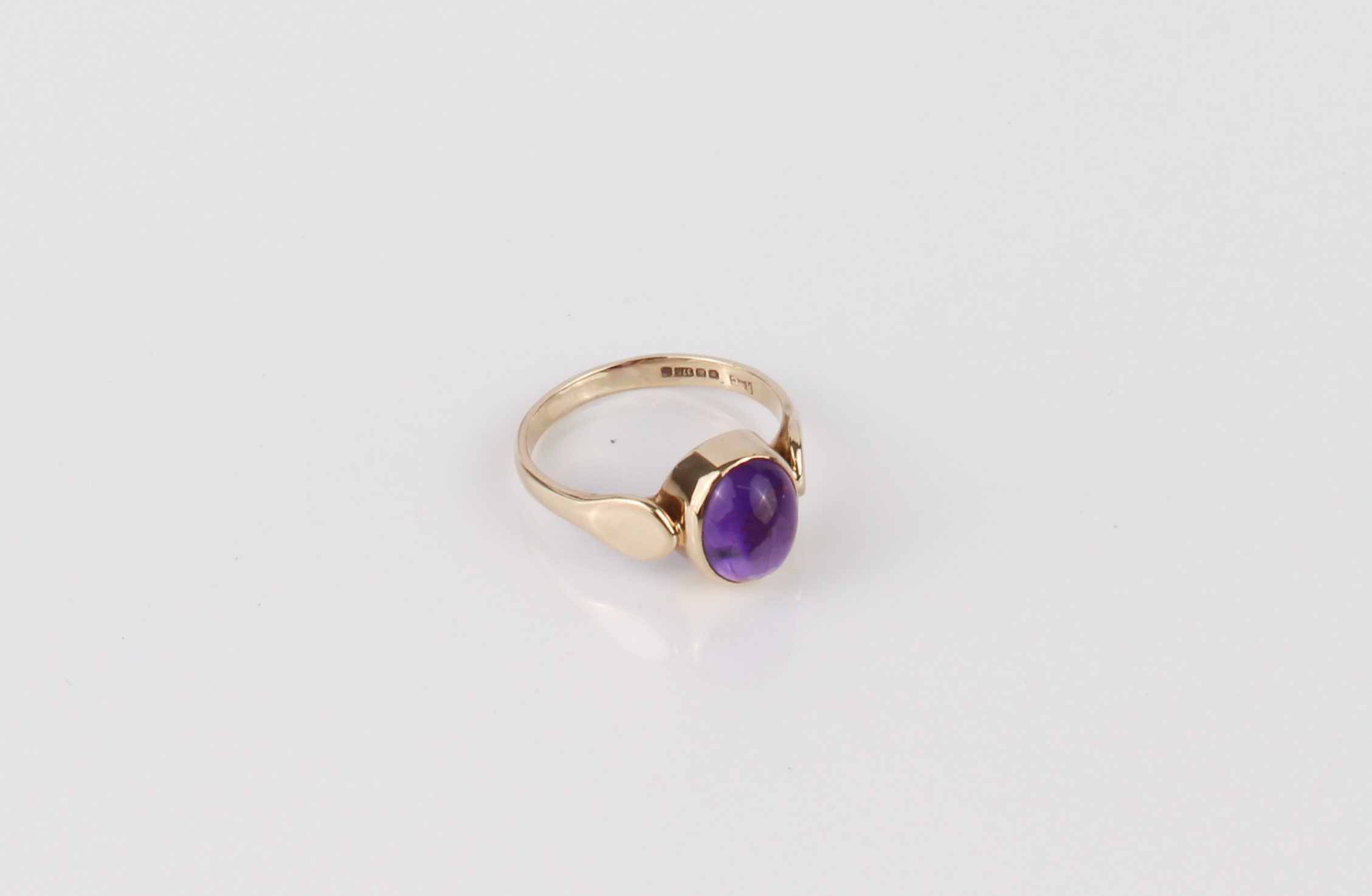 A 9ct gold and amethyst ring - hallmarked Sheffield 1996, the 9 x 7mm cabochon amethyst in a