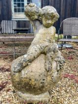 A composite stone statue of the young Bacchus sitting upon an upturned wine jar - 53 x 43cm x 90cm