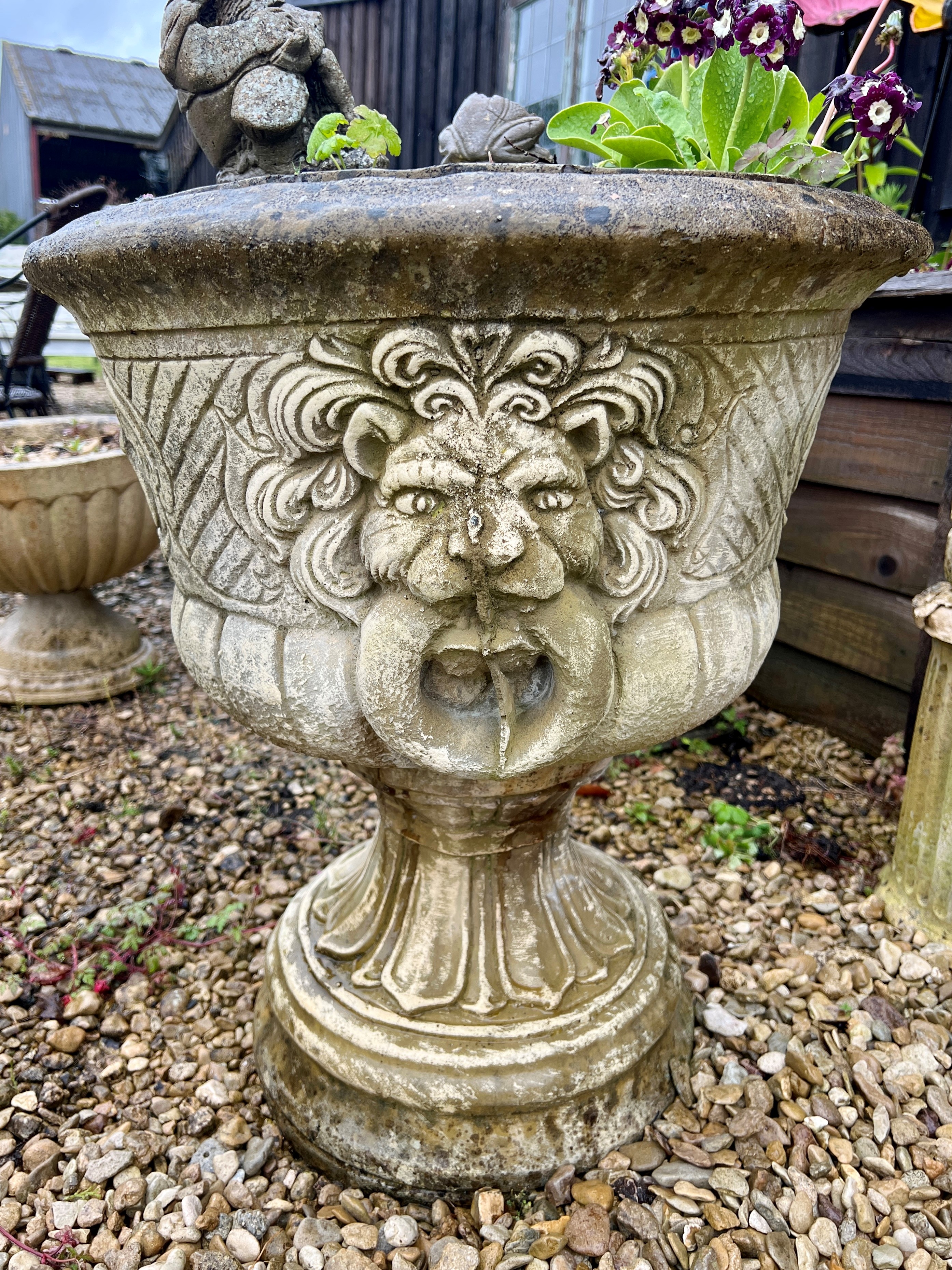 A pair of composite garden urns with lion mask handles - the bowl 55cm diameter, 63cm high.