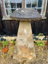 A Cotswold stone staddle stone - the top 39cm diameter x 13cm high, the base 50 x 36 x 94cm, 107cm