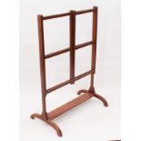 An Edwardian mahogany folding towel rail - with three rails and hinged sides, on arched supports