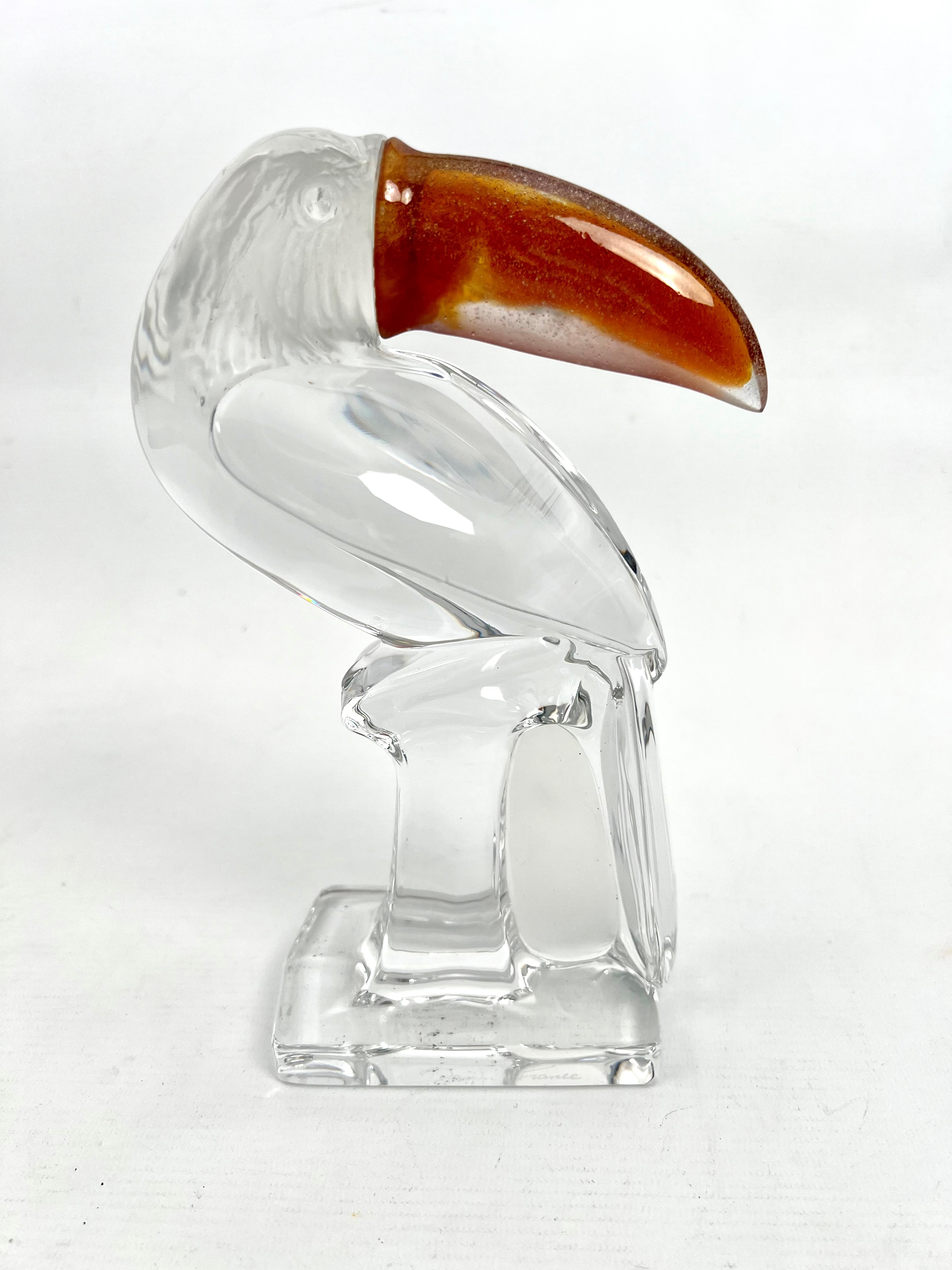 A Daum Crystal glass figure of a toucan - in clear glass with a frosted glass head with amber