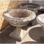 A pair of large composite stone campana style garden urns - well weathered, decorated with foliage