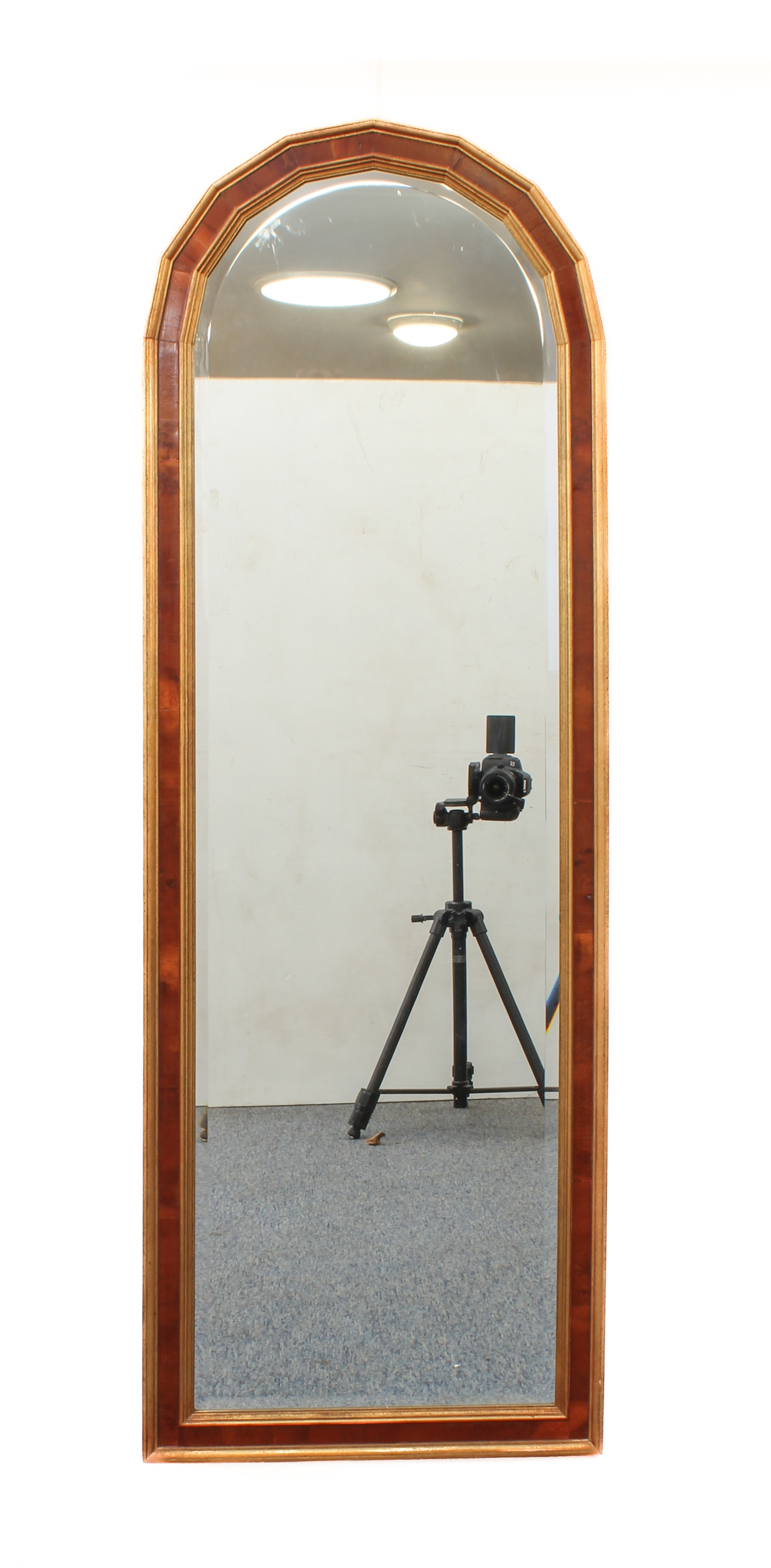 A yew veneered and parcel-gilt arched mirror - modern, with bevelled plate. (133 x 45.5 cm)