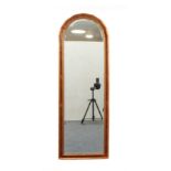 A yew veneered and parcel-gilt arched mirror - modern, with bevelled plate. (133 x 45.5 cm)