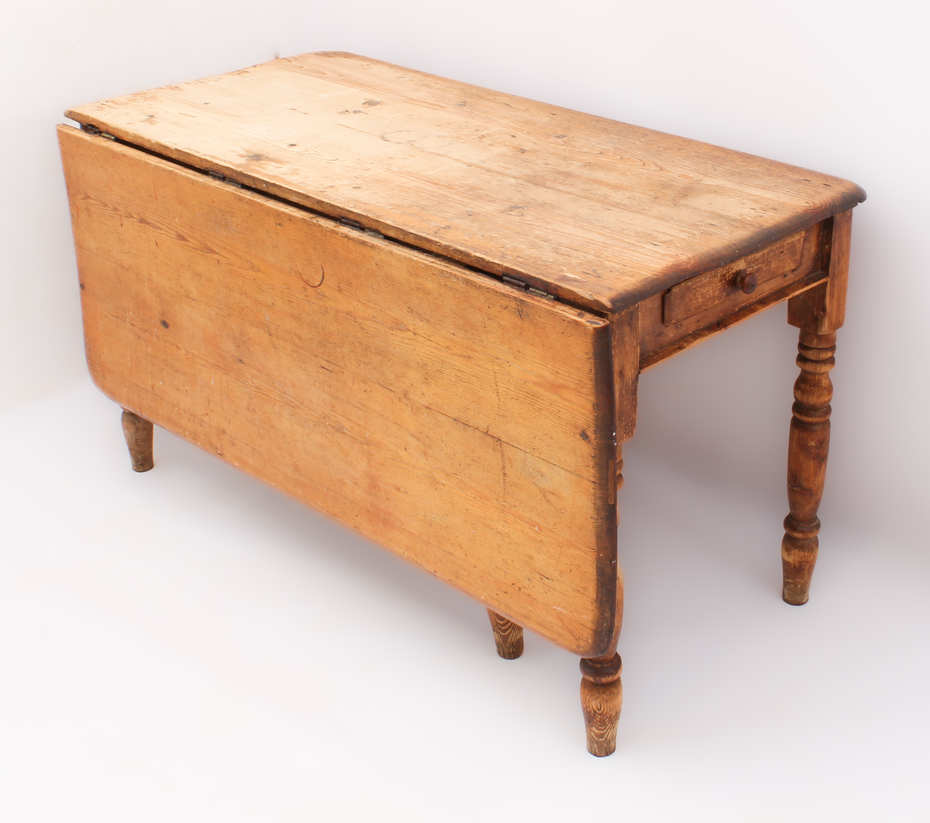 A 19th century pine farmhouse dining table with single dropflap - the rectangular top over two end-