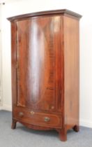 An Edwardian inlaid mahogany bowfront wardrobe - the flared, key carved cornice over a single oval