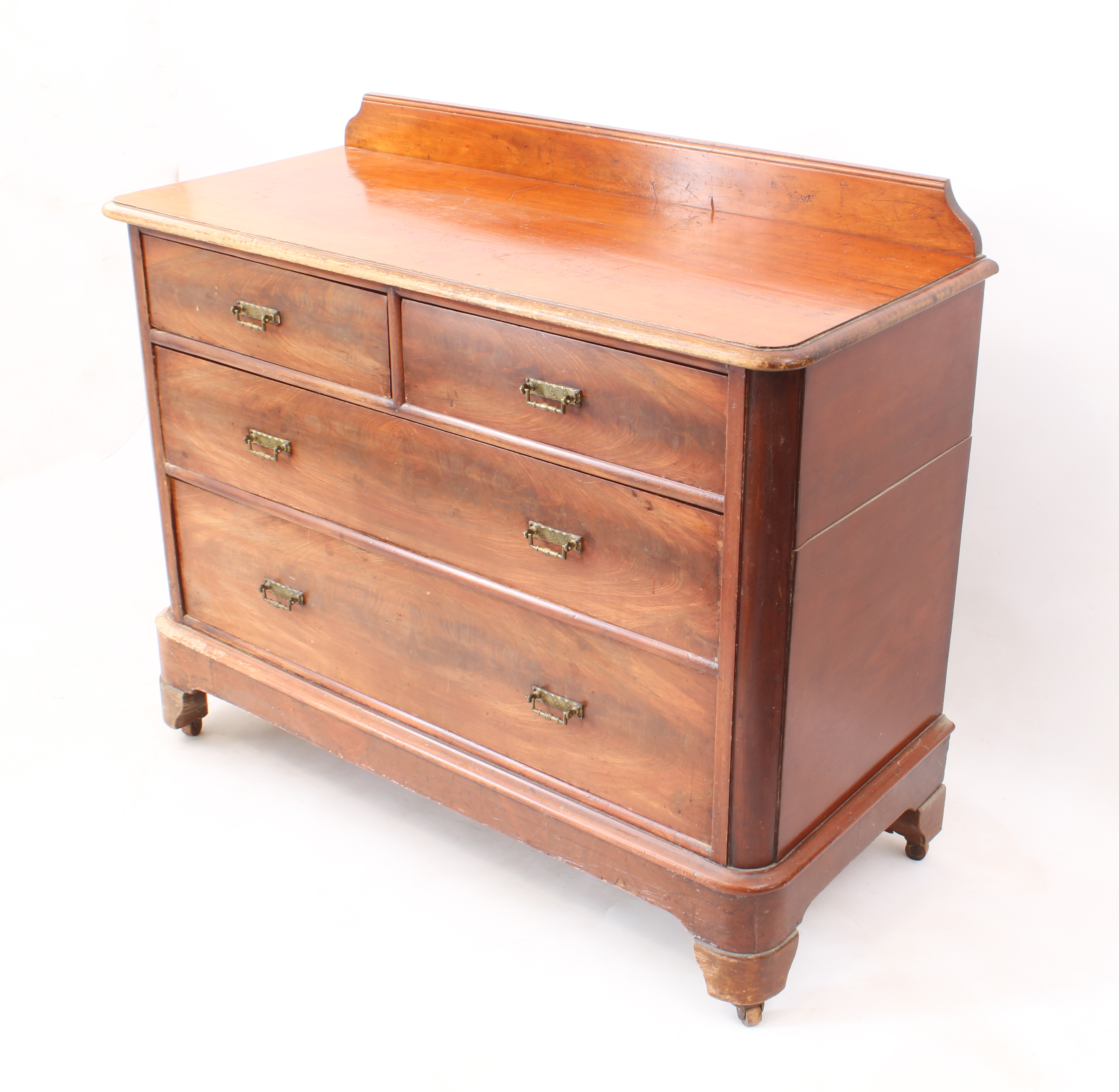 A late 19th century mahogany chest of drawers - the moulded top with short upstand over two short