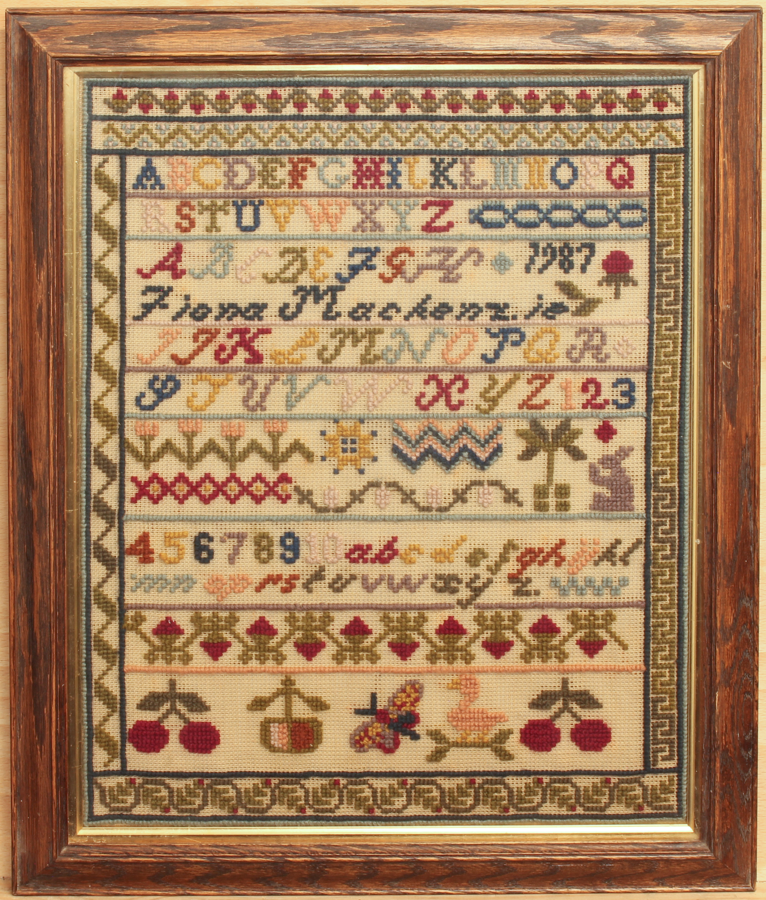 A 20th century sampler - inscribed 'Fiona Mackenzie 1987', with alphabet and numerical panels over