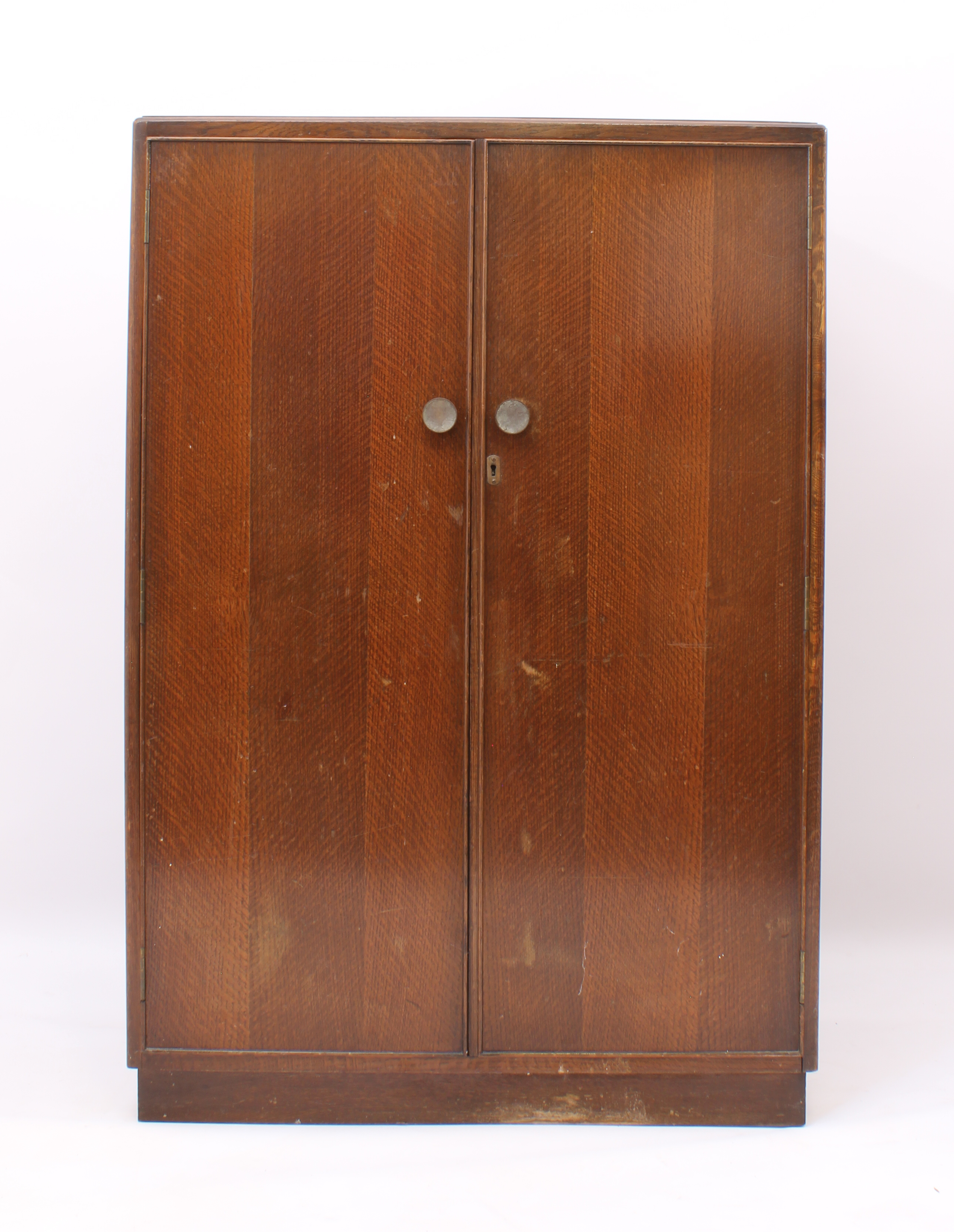 A 1940s-50s oak child's compactum wardrobe - striped veneered doors and inset plinth base, the
