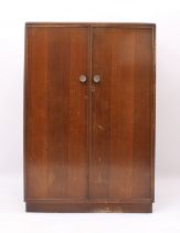 A 1940s-50s oak child's compactum wardrobe - striped veneered doors and inset plinth base, the