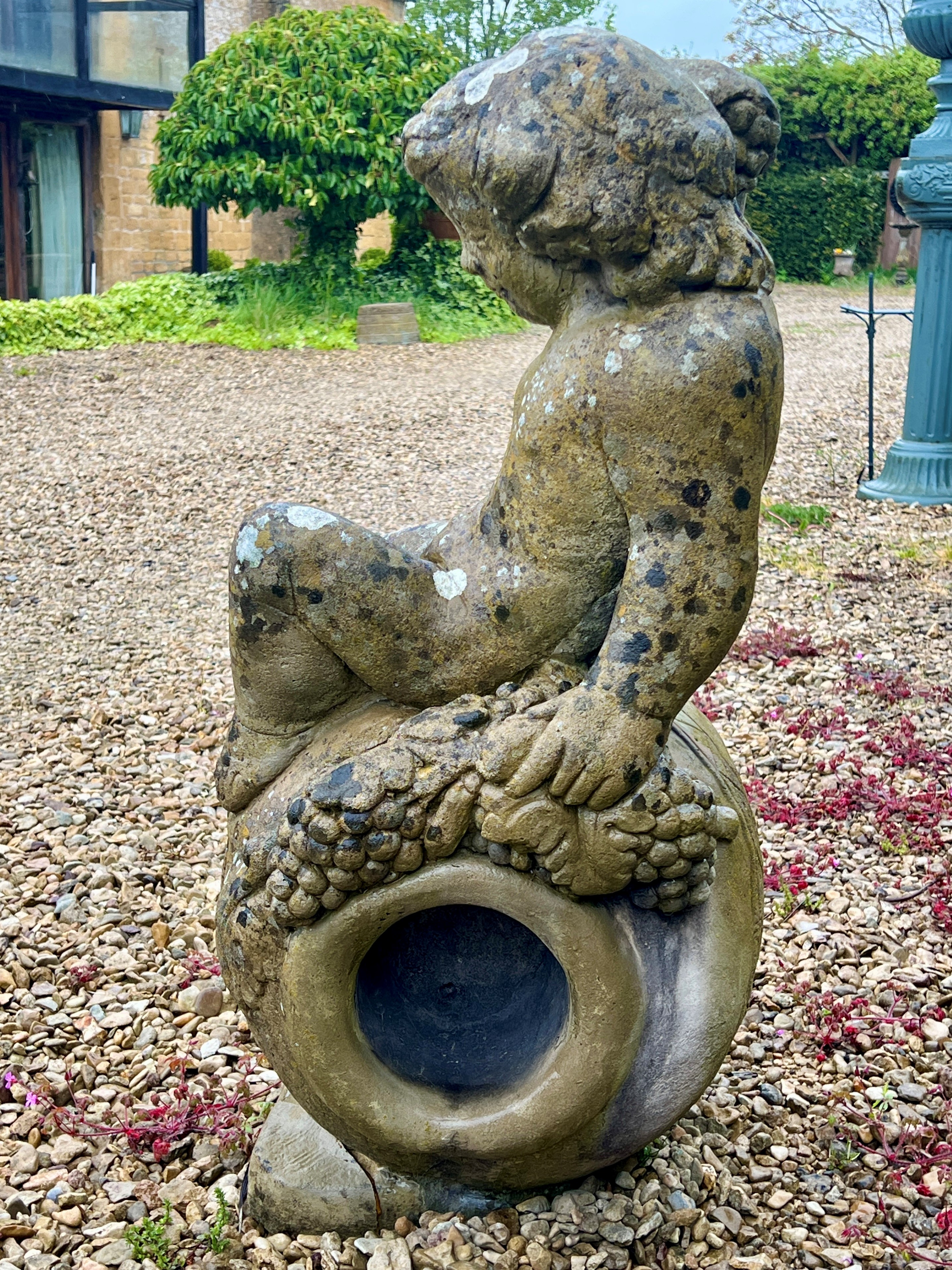 A composite stone statue of the young Bacchus sitting upon an upturned wine jar - 53 x 43cm x 90cm - Image 2 of 4