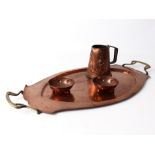 Four pieces of Arts & Crafts copper ware - all early 20th century, comprising a planished copper and