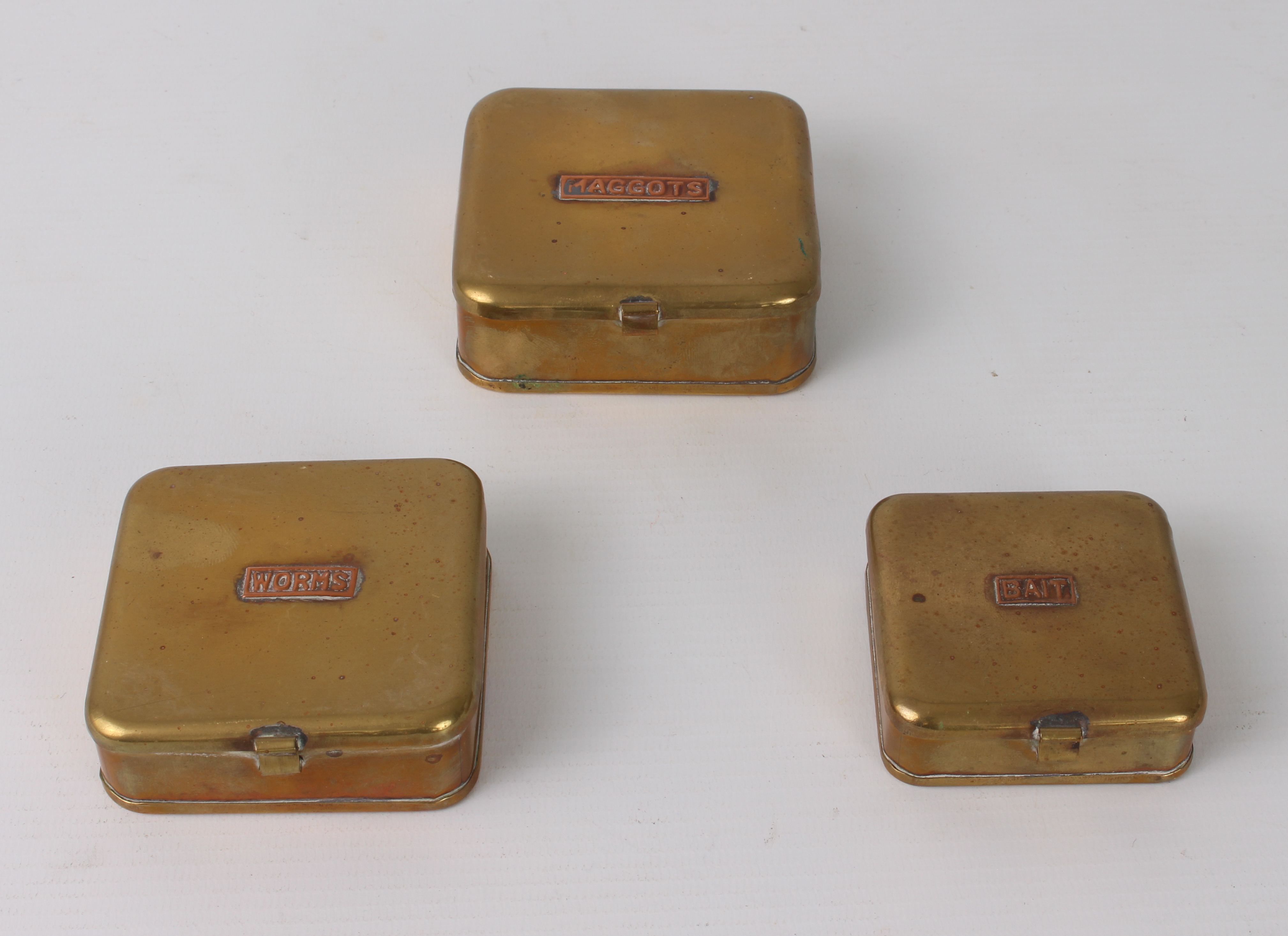 A graduated set of three brass and copper fishing bait boxes - square form with hinged lids,