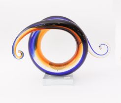 An art glass sculpture - of scrolled, spiral form, in dark-blue, amber and clear glass, each end