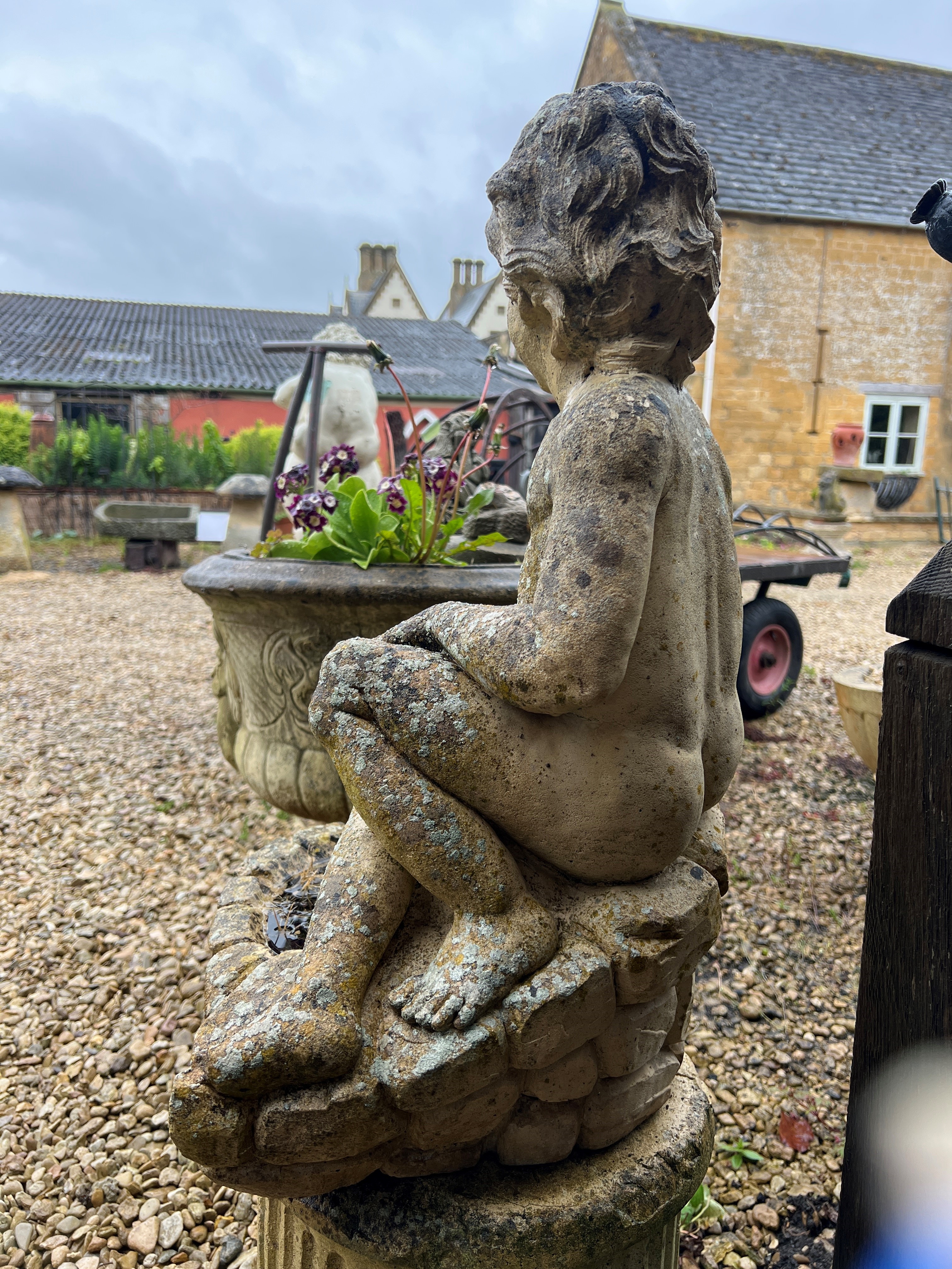 A composite stone garden statue of a seated boy - 64cm high. - Image 2 of 3