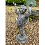 A lead statue of a winged cherub with arms aloft - 69cm high.