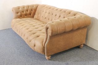 A leather Chesterfield three-seater sofa - modern, in soft pale-brown grained leather, raised on