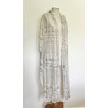 An Egyptian Assuit shawl - mid-20th century, in ivory cotton gauze with decoration of foliage,