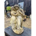 A composite stone statue of a young couple embracing - 70cm high.