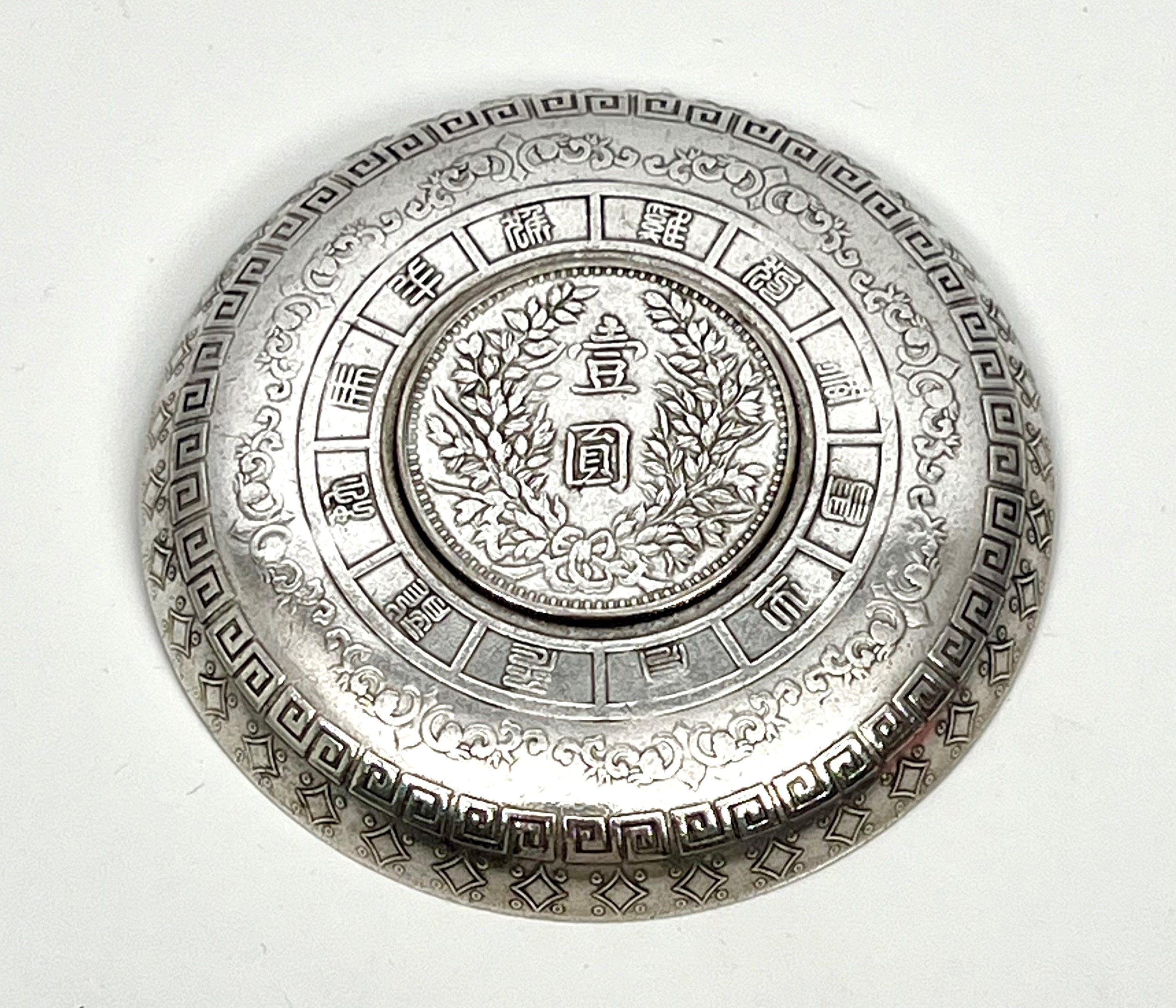 A Chinese white metal zodiac dish - inset with a Chinese $1 one dollar coin, within a flowerhead - Image 2 of 2