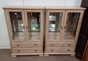 PAIR OF LIMED OAK EFFECT DISPLAY CABINETS WITH 2 GLAZED PANEL DOORS OVER 2 DRAWERS.