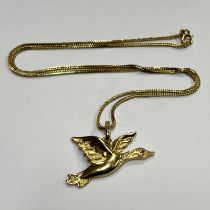 14CT GOLD RUBY SET DUCK IN FLIGHT PENDANT ON AN ARABIC GOLD CHAIN - 9.