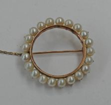 CIRCULAR PEARL SET BROOCH IN A YELLOW METAL MOUNT - 3CM DIAMETER