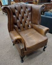 BROWN LEATHER BUTTONED WINGBACK ARMCHAIR ON SHORT QUEEN ANNE SUPPORTS LABELLED 'WINCHESTER