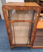 ART DECO STYLE WALNUT DISPLAY CABINET WITH SINGLE GLAZED PANEL DOOR OPENING TO GLASS SHELF INTERIOR.