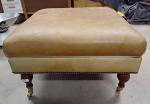 TAN LEATHER CENTRE STOOL WITH LIFT UP TOP ON TURNED SUPPORTS.
